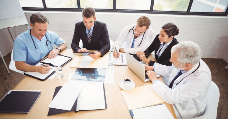 Healthcare professionals working around a conference table